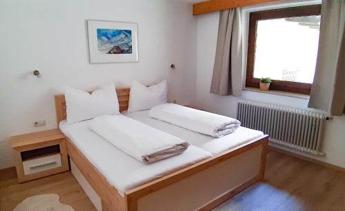 Ένα ή περισσότερα κρεβάτια σε δωμάτιο στο Berghaus Praxmarer