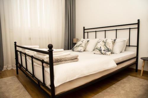 a bedroom with a black bed with white sheets and pillows at Room21 FREE GARAGE in Novi Sad