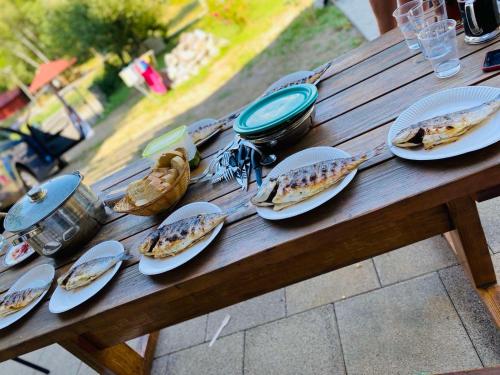 a wooden picnic table with plates of food on it at SanMari_forest in Ledenice
