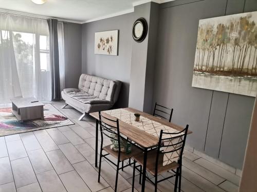 un soggiorno con tavolo e divano di Menlyn Maine Apartments, Menlyn Place a Pretoria