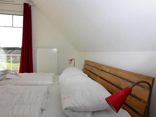 een slaapkamer met 2 bedden en een rood gordijn bij Holiday home, Friedrichskoog-Spitze in Friedrichskoog-Spitz