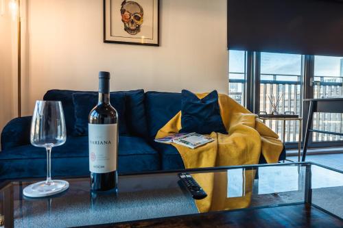 a bottle of wine sitting on a table next to a couch at City View - A Stunning 2 Bed Apartment in Glasgow