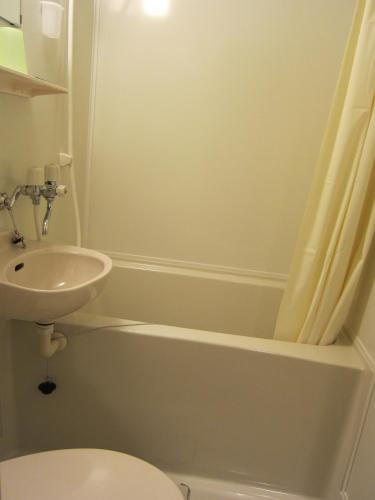 a bathroom with a sink and a toilet and a shower at Kunsthaus in Biei