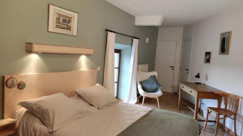 1 dormitorio con cama, escritorio y silla en Le Clos Marie, en Ciney