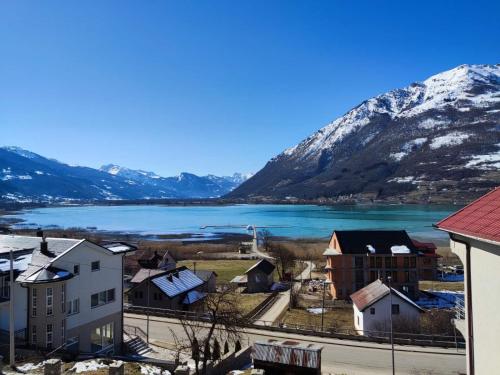 a town with a lake and snow covered mountains at Apartments & Rooms Brijest in Plav