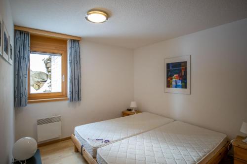 貝特默阿爾卑的住宿－Bettmerlodge，一间卧室设有一张床和一个窗口