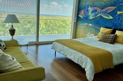 une chambre avec un lit et une grande fenêtre dans l'établissement Madère - Villa, piscine privée, splendide vue Bassin d'Arcachon, à Gujan-Mestras