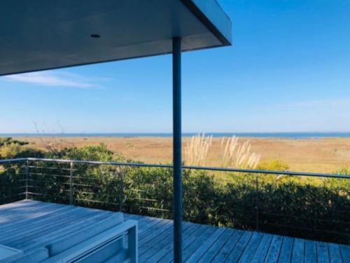 une terrasse en bois avec vue sur l'océan dans l'établissement Madère - Villa, piscine privée, splendide vue Bassin d'Arcachon, à Gujan-Mestras