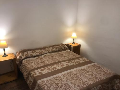 1 dormitorio con 1 cama y 2 lámparas en las mesas en Mageeva Miramar Bs As Argentina Departamentos en Miramar
