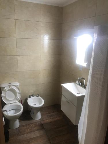 a bathroom with a toilet and a sink at Mageeva Miramar Bs As Argentina Departamentos in Miramar
