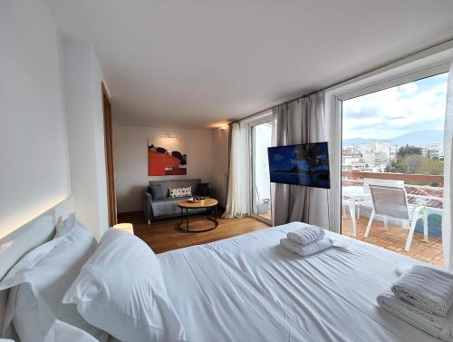 a bedroom with a white bed and a large window at Vivo Apartments in Athens