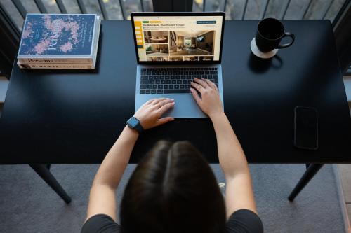 a woman is typing on a laptop computer at City View - A Stunning 2 Bed Apartment in Glasgow