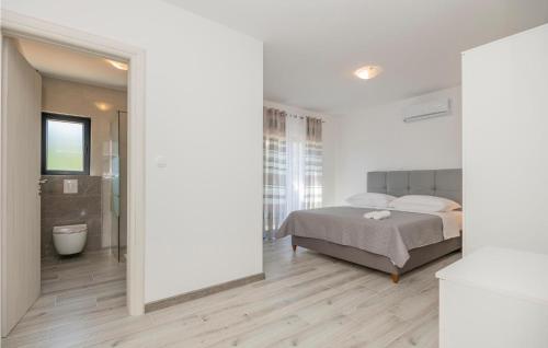 a white bedroom with a bed and a bathroom at Gorgeous Home In Grubine in Grubine