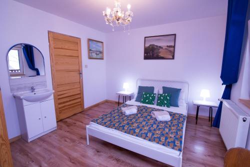 a bedroom with a bed and a sink and a chandelier at Gościniec Tokarzonka in Istebna