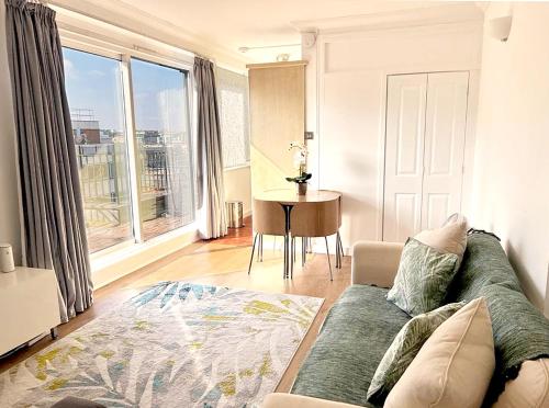 - un salon avec un canapé et une table dans l'établissement W1 Penthouse w Terrace, à Londres