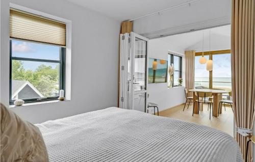 a bedroom with a bed and a table with chairs at Awesome Apartment In Kerteminde With House Sea View in Kerteminde