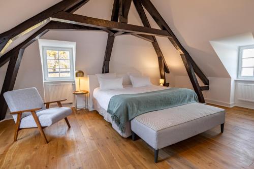 a bedroom with a bed and a chair at Domaine Mont-Riant à Jurançon in Jurançon