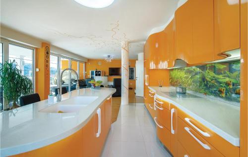 eine orangefarbene Küche mit orangefarbenen Schränken und weißen Arbeitsplatten in der Unterkunft 5 Bedroom Awesome Home In Varazdinske Toplice in Varaždinske Toplice