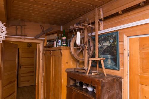 a room with a wooden wall with a spinning wheel at Gościniec Tokarzonka in Istebna