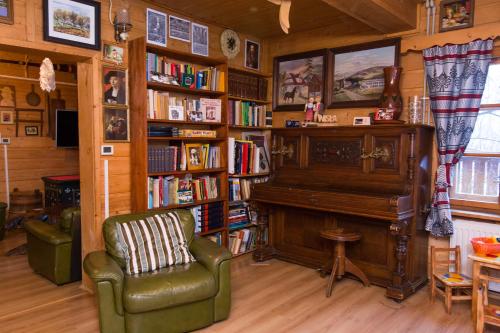 a living room with a piano and a book shelf at Gościniec Tokarzonka in Istebna