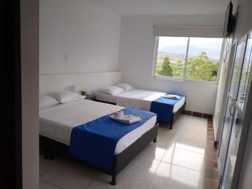 two beds in a room with a window at BONANZA in Monterrey