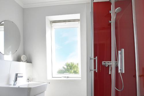a bathroom with a red shower and a sink at Hamburg-App-09 in Ahlbeck