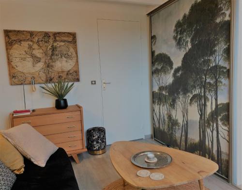 sala de estar con mesa de centro y una pintura en la pared en Puytraud Mer, en Saint-Palais-sur-Mer