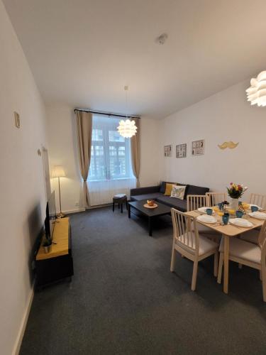 Little Tom Apartments في براغ: غرفة معيشة مع أريكة وطاولة