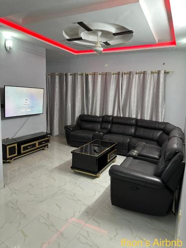 a living room with a black leather couch and a flat screen tv at Ifson Home 2 in Kankamsen