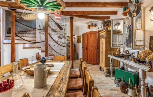 uma cozinha com uma longa mesa de madeira e cadeiras em Lovely Home In Kostrena With Kitchen em Kostrena