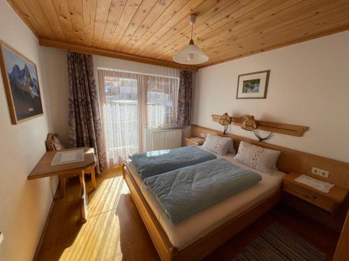 1 dormitorio con cama y escritorio. en Ferienhaus Reinhard Steiner en Hinterbichl