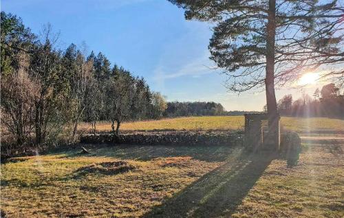 a park with a bench and a tree in a field at 5 Bedroom Nice Home In Borgholm in Borgholm