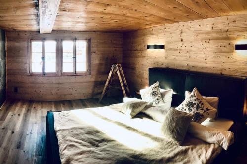 una camera da letto con letto in una camera in legno di Luxury & Cosy 3.5 rooms apartment in almost 300 years old Chalet a Leukerbad