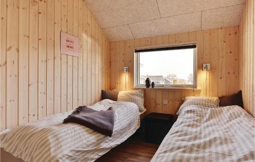 Skåstrupにある5 Bedroom Awesome Home In Bogenseのウッドウォールと窓が備わるドミトリールームのベッド2台分です。