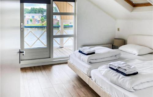 two beds in a room with a large window at It Soal Waterpark-waterlelie in Workum
