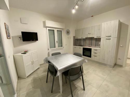 a kitchen with a table and chairs in a room at APPARTAMENTO VENERE in Cecina