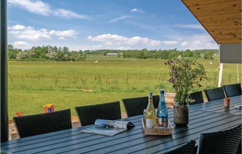 a wooden table with bottles of wine and a field at Four-Bedroom Holiday Home In Odder in Odder