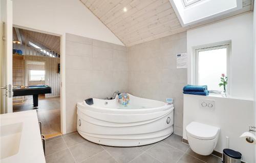 a bathroom with a tub and a toilet and a sink at Nice Home In Odder With 4 Bedrooms, Sauna And Wifi in Odder