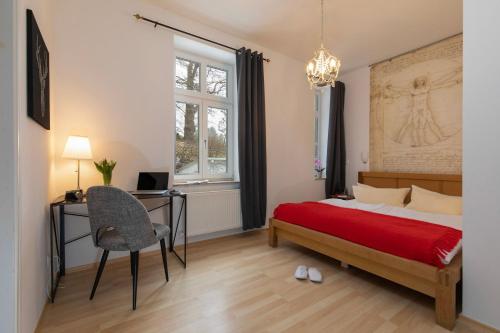 una camera con letto, scrivania e sedia di Villa Sanssouci - Bäderstilvilla mit individuellen Wohnungen a Binz