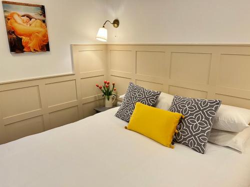a bedroom with a white bed with a yellow pillow at Ferndale Mews in Bristol