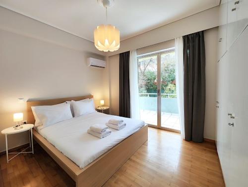 um quarto com uma cama com lençóis brancos e uma janela em Etolou A2 - by Verde Apartments em Atenas