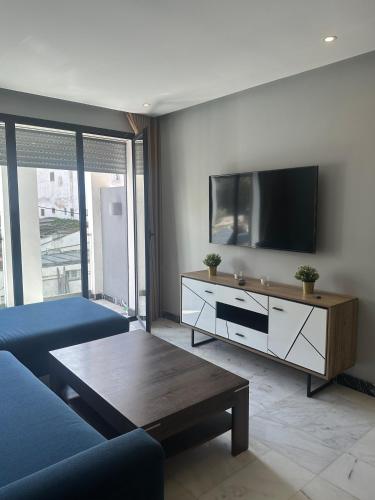 a living room with a blue couch and a tv at Twin Center Oasis - Luxury Apartment with Free Parking in Casablanca