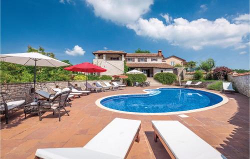 une piscine avec des chaises longues et une maison dans l'établissement Awesome Home In Visnjan With Jacuzzi, à Višnjan