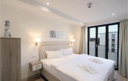 a bedroom with a large white bed with a window at Garden Suite in Binz