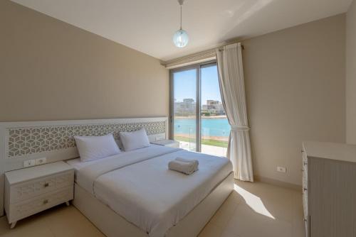 a bedroom with a bed and a large window at Ascot Bay, Premium 5BR Lagoon Beach House & Pool in Tawila, El Gouna in Hurghada