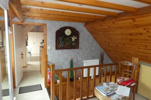Cette chambre dispose d'un plafond en bois avec une horloge et une table. dans l'établissement Studio Bourgois, à Berck-sur-Mer