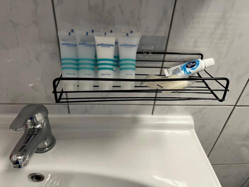 un estante sobre un fregadero con cepillos de dientes y pasta de dientes en Jakov Apartments en Orebić