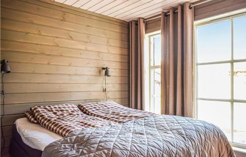 a bed in a bedroom with a wooden wall at Nice Home In Vringsfoss With 4 Bedrooms And Wifi in Maurset
