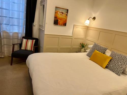 um quarto com uma grande cama branca e uma almofada amarela em Ferndale Mews em Bristol