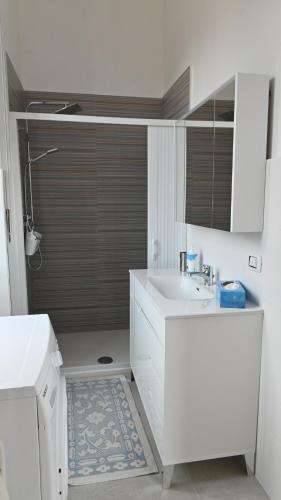 Baño blanco con lavabo y espejo en La Veranda Beach, en Agropoli